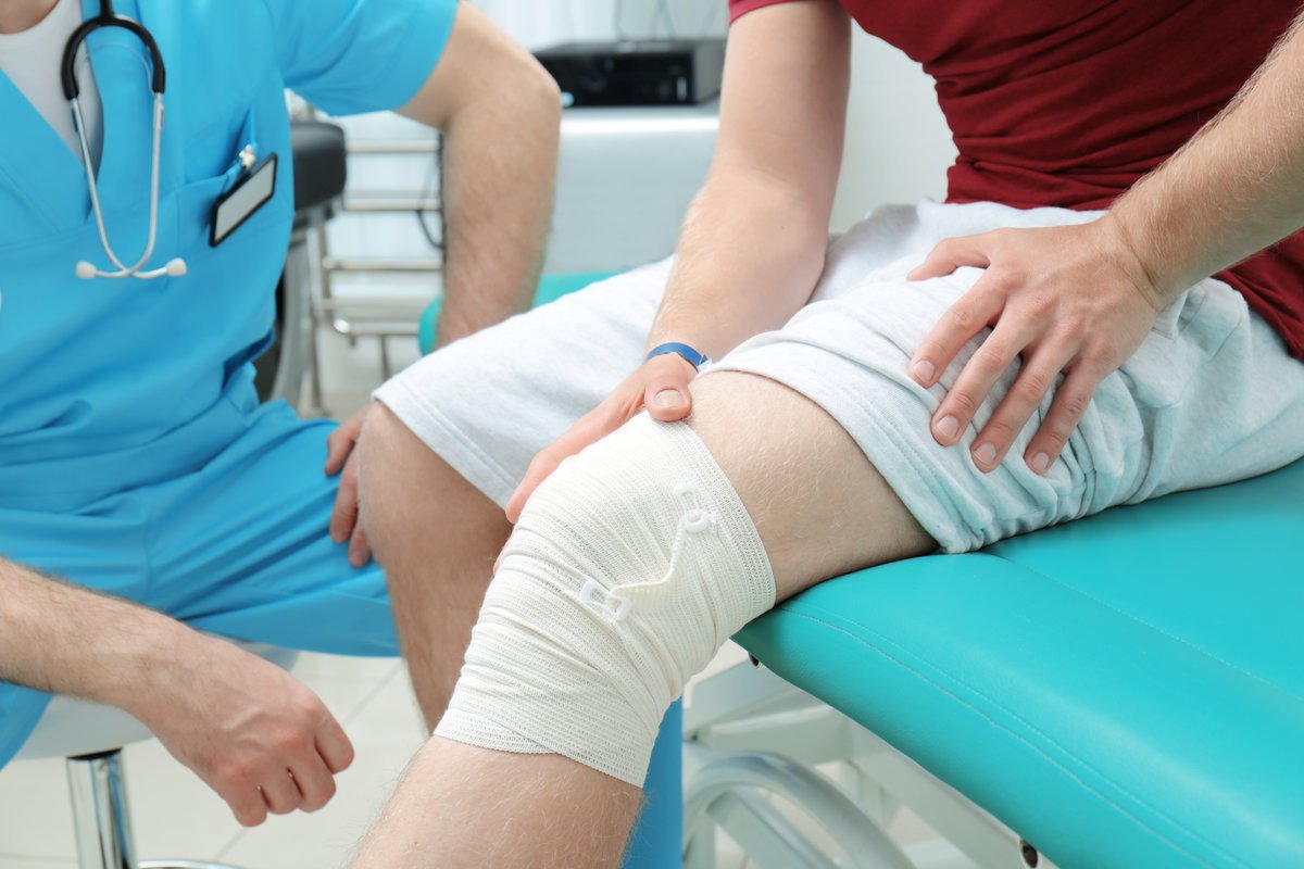 Orthopedist examining patient in clinic